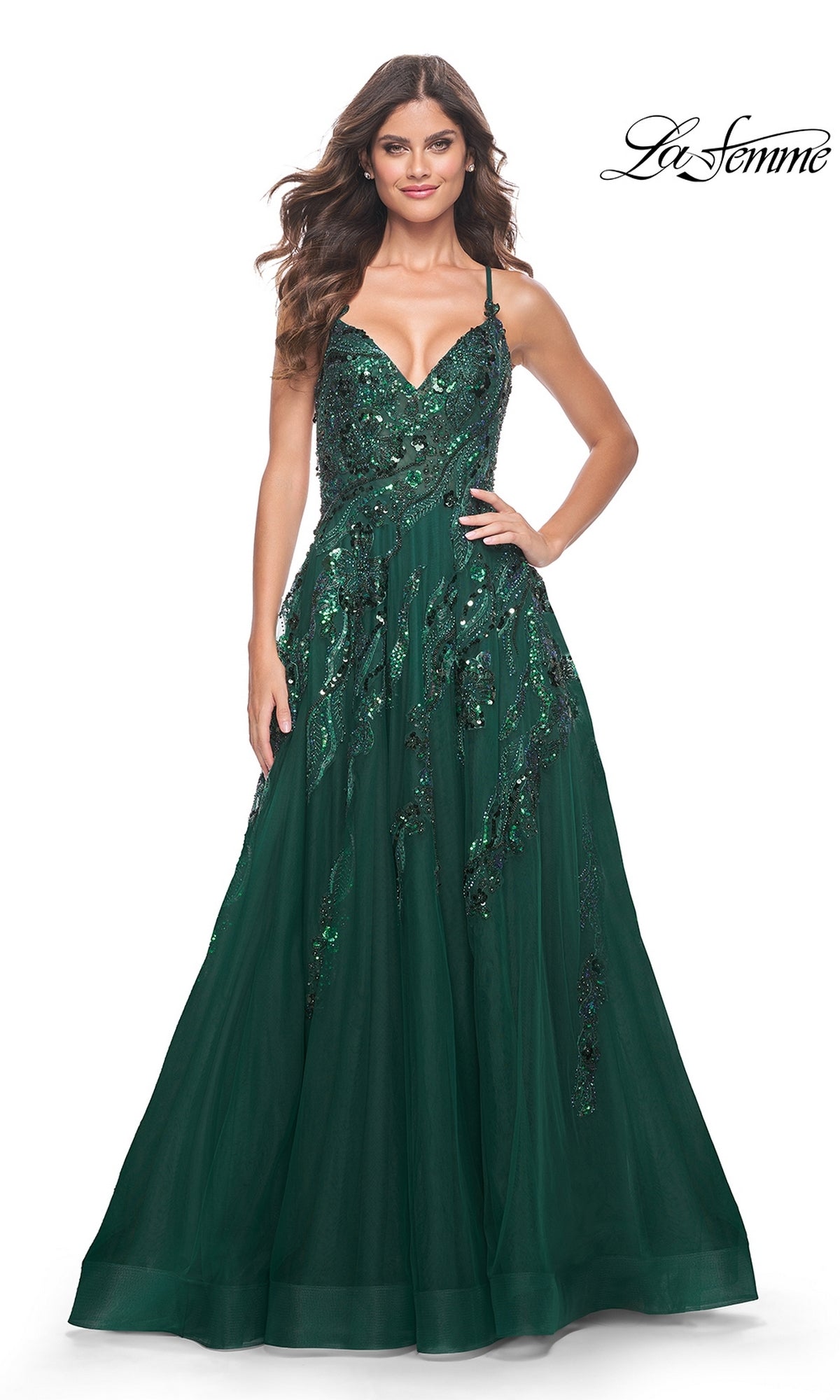 A woman wears the La Femme Long A-Line Sequin-Print Prom Dress 32346 in dark green with spaghetti straps and shimmering sequins, standing against a white background. The La Femme logo appears in the top right corner.